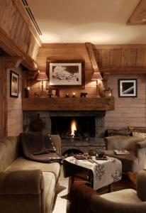a living room with a couch and a fireplace at Hotel Beauregard in La Clusaz
