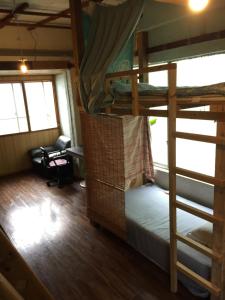 a room with two bunk beds and a desk at Asahi Guest House in Naha