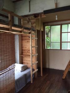 1 dormitorio con litera y ventana en Asahi Guest House en Naha