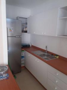 a kitchen with a refrigerator and a sink at Depto. frente al mar in Tomé