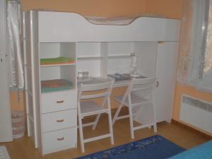 a bunk bed with a desk and two chairs at Jannseni Accommodation in Pärnu