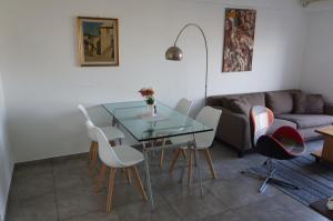 a living room with a glass table and chairs at Ático Palermo in Buenos Aires