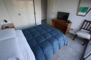 sypialnia z łóżkiem, krzesłem i telewizorem w obiekcie Ático Palermo w BuenosAires