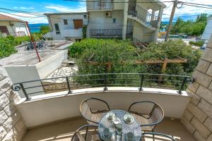 a balcony with a table and chairs on it at Apartments Villa Aquamarine in Duće