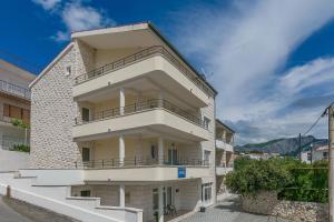 a white building with balconies on the side of it at Apartments Villa Aquamarine in Duće
