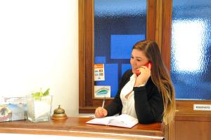 a woman sitting at a desk talking on a cell phone at Hotel Villa Felice Relais in Amalfi