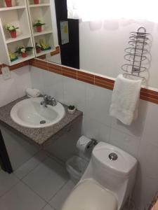 曼塔的住宿－藍色太平洋旅舍，浴室配有白色水槽和卫生间。