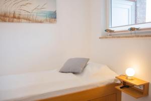 a bedroom with a bed with a lamp and a window at Haus am Deich Wohnung 4 in Dahme