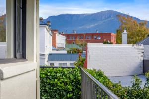 a balcony with a view of a city and mountains at Battery Point Boutique Accommodation in Hobart