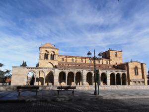 un gran edificio de ladrillo con bancos delante en Paneras del Rey, en Ávila