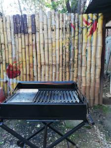 a grill in front of a fence with a bunch of logs at Aventura Chachapoyas Backpackers in Chachapoyas