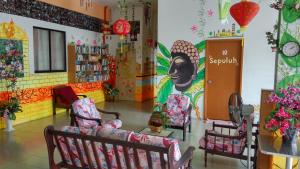 マラッカにあるOld Town Guest Houseの椅子と壁画のある部屋