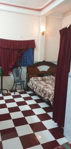 a bedroom with a bed and a checkered floor at Nhà Trọ Kim Ánh in Long Xuyên