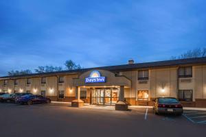 a hotel with cars parked in a parking lot at Days Inn by Wyndham Iselin / Woodbridge in Iselin