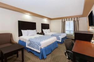 a hotel room with two beds and a desk at Days Inn by Wyndham Iselin / Woodbridge in Iselin