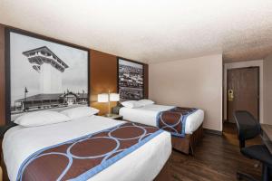a hotel room with two beds and a desk at Super 8 by Wyndham North Platte in North Platte