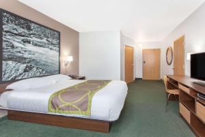 a hotel room with a bed and a flat screen tv at Super 8 by Wyndham Kenora in Kenora