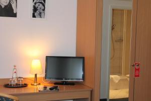- une télévision assise sur une table dans une chambre d'hôtel dans l'établissement Filmhotel Lili Marleen, à Potsdam