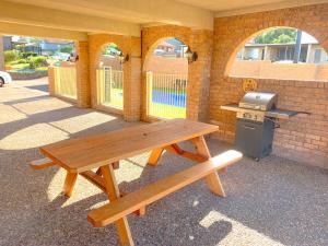 a wooden bench sitting in front of a building at Cumberland Motor Inn in Cessnock