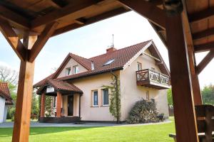 a house with a balcony on top of it at Apartamenty i Domki Osińscy in Braniewo