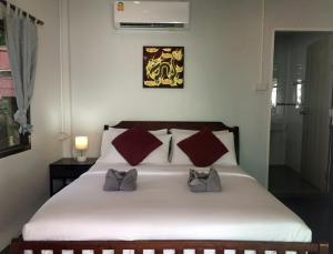 1 dormitorio con 1 cama blanca y 2 almohadas en Sunrise Villas Seaview, en Ko Samed
