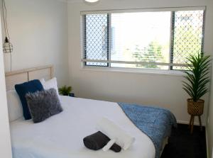 a bedroom with a bed with a towel on it at Kings Beach Retreat in Caloundra