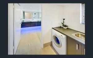 a kitchen with a sink and a washing machine at Kings Beach Retreat in Caloundra