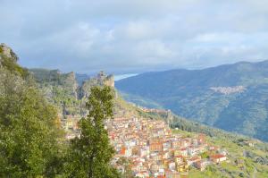 a town on a hill with mountains in the background at Su Marmuri in Ulassai