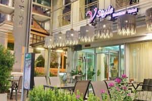 a restaurant with chairs and chandeliers in front of a building at V Style Pattaya North Beach in Pattaya