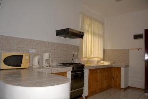 a kitchen with a microwave and a counter top at Villas Pingouin in Blue Bay