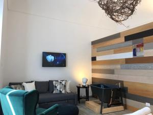 a living room with a couch and a tv on a wall at Terra di Sicilia Luxury Centro in Avola