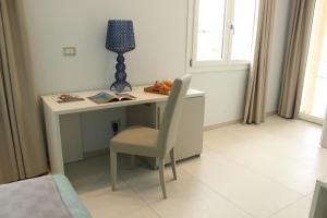 a desk with a chair and a lamp in a room at 103 Boutique Hotel Stintino in Stintino