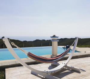 a hammock sitting on a deck next to a pool at Casamediterranea in Sperlonga