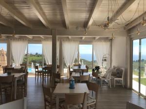 a restaurant with tables and chairs and large windows at Casamediterranea in Sperlonga