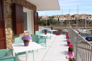 a balcony with tables and chairs and a marina at 103 Boutique Hotel Stintino in Stintino
