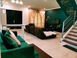uma sala de estar com paredes verdes e um sofá em MiCasa 2 Homestay em Sibu