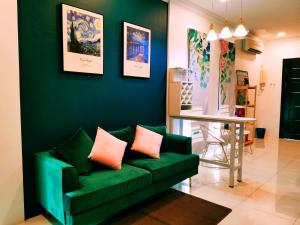 a living room with a green couch and a table at MiCasa 2 Homestay in Sibu