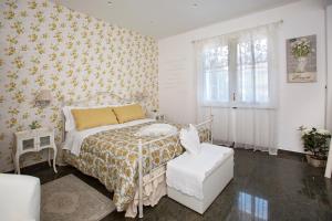 ニコロージにあるB&B Blanc Maison Etna Relais & Charmeのベッドと椅子のある白い寝室