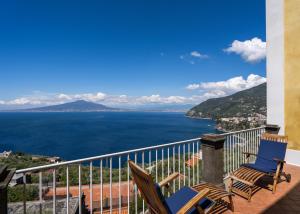 2 Stühle auf einem Balkon mit Meerblick in der Unterkunft Hotel Torre Barbara in Vico Equense