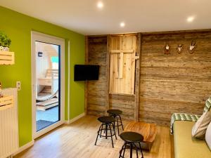 a living room with green walls and stools at Boutique Appartments AlteGreißlerei in St. Wolfgang