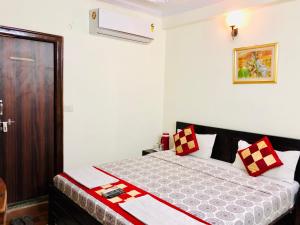 een slaapkamer met een bed met rode en witte kussens bij Hotel Classic Inn Jaipur in Jaipur