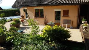 a backyard of a house with bushes and plants at LE ROSSIGNOL in Cranves-Sales +14 photos