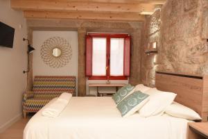a bedroom with a white bed and a window at Casa Choupas in Cangas de Morrazo