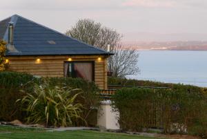 a wooden cabin with a view of the water at Rustic Log Cabin in Greencastle