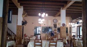 een eetkamer met tafels en een klok aan de muur bij To Ellinikon in Omalós