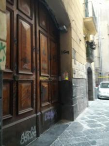 ein Gebäude mit einer großen Holztür auf einer Straße in der Unterkunft Spazio in Neapel