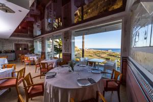 ein Restaurant mit Tischen und Stühlen und Meerblick in der Unterkunft Hotel Salambina in Salobreña