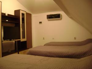 シビウにあるApartment Atticのベッド2台、薄型テレビが備わるホテルルームです。