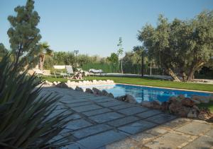 una piscina en un patio con árboles y césped en Villa Capricho de Luna, en Caparacena