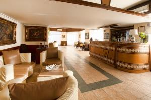 eine Lobby mit Sofas und Sesseln sowie einer Bar in der Unterkunft Hotel Scacciapensieri in Nettuno